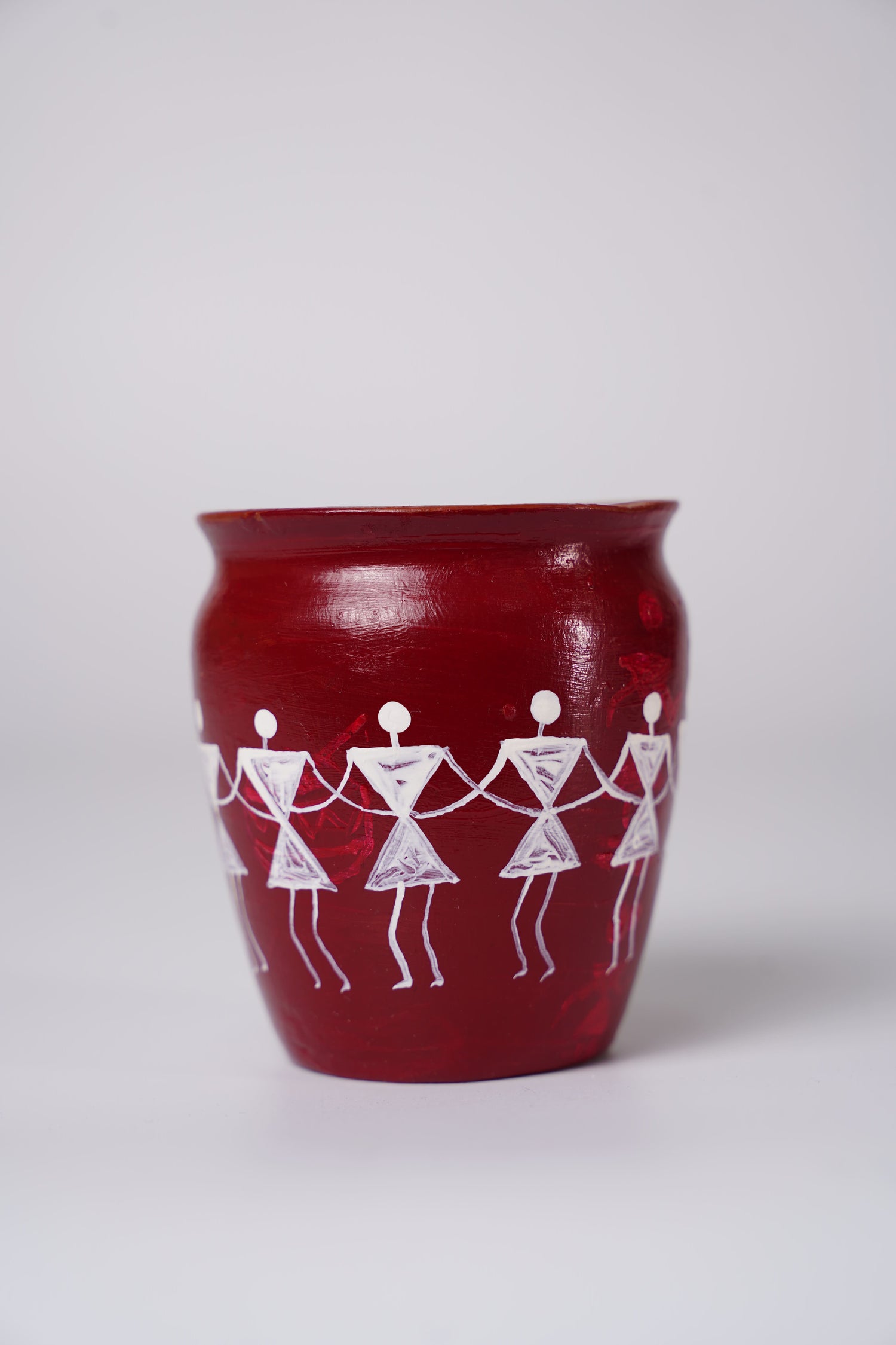 hand-painted terracotta pot featuring traditional Warli art